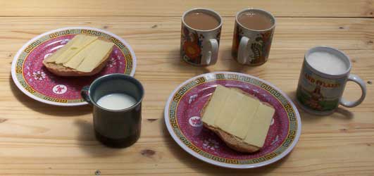 [lunch: slices of bread with cheese, milk, coffee]