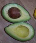 [an avocado cut open, showing flesh and pit]